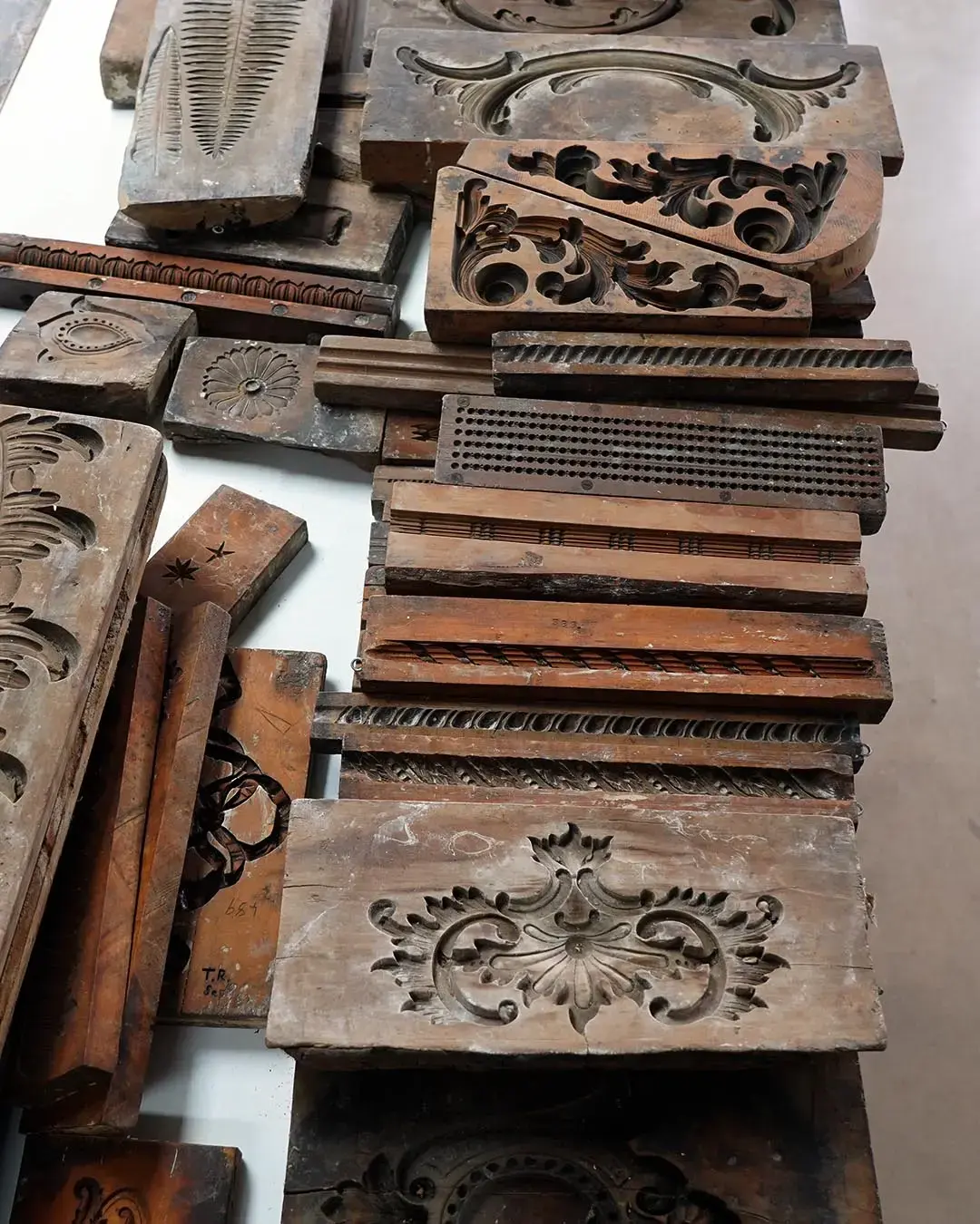 A collection of hand-carved wooden ornament moulds used to cast bespoke frame profiles
