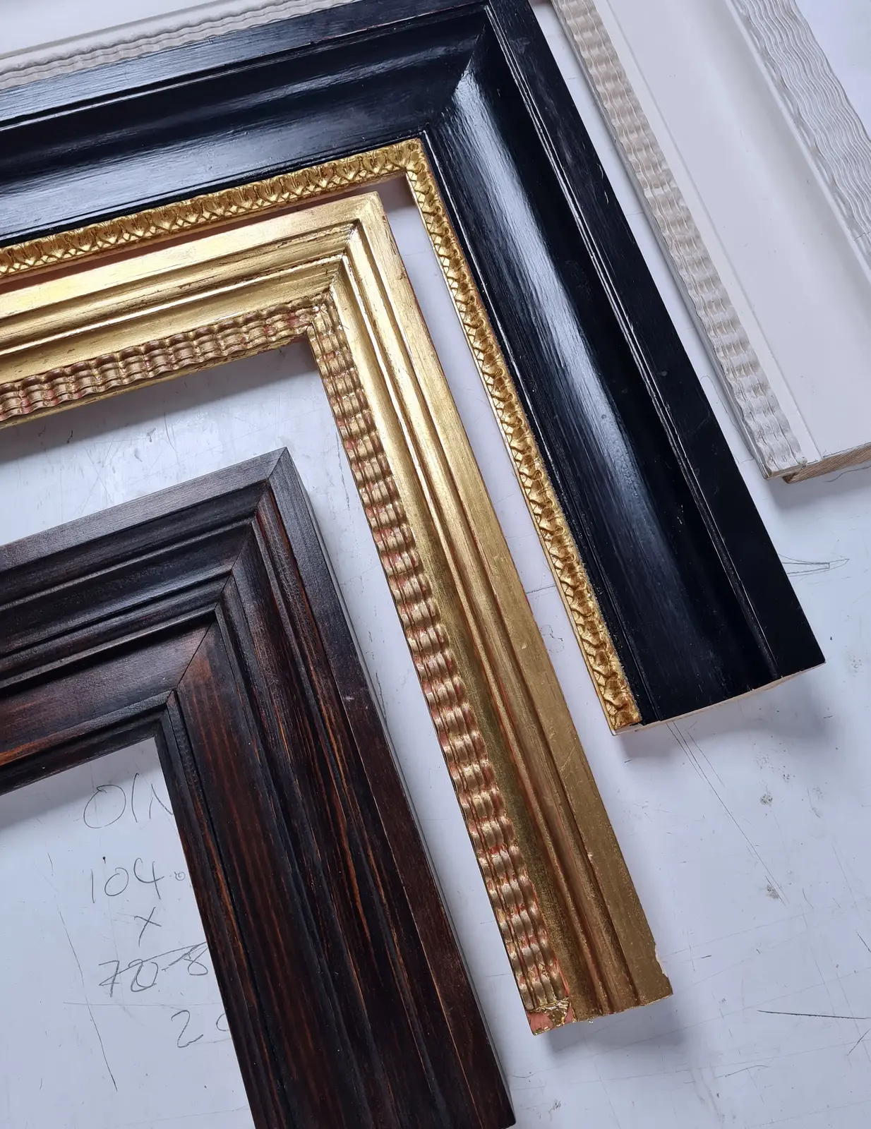 A selection of contemporary frame profiles in black lacquer, gilt and dark wood