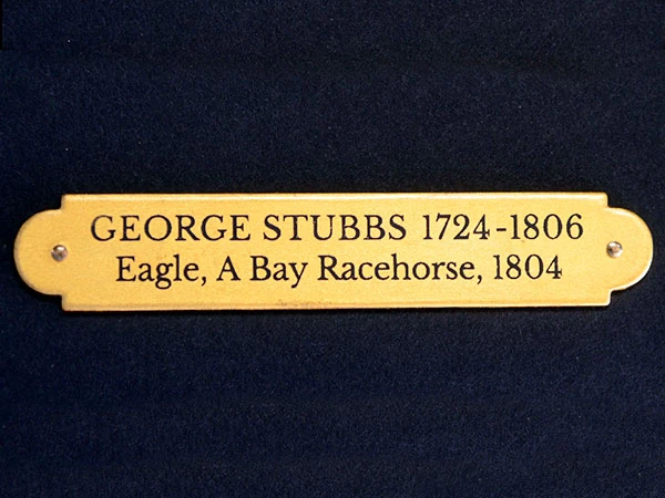 A collection of gold leaf plaques bearing artists' names and dates